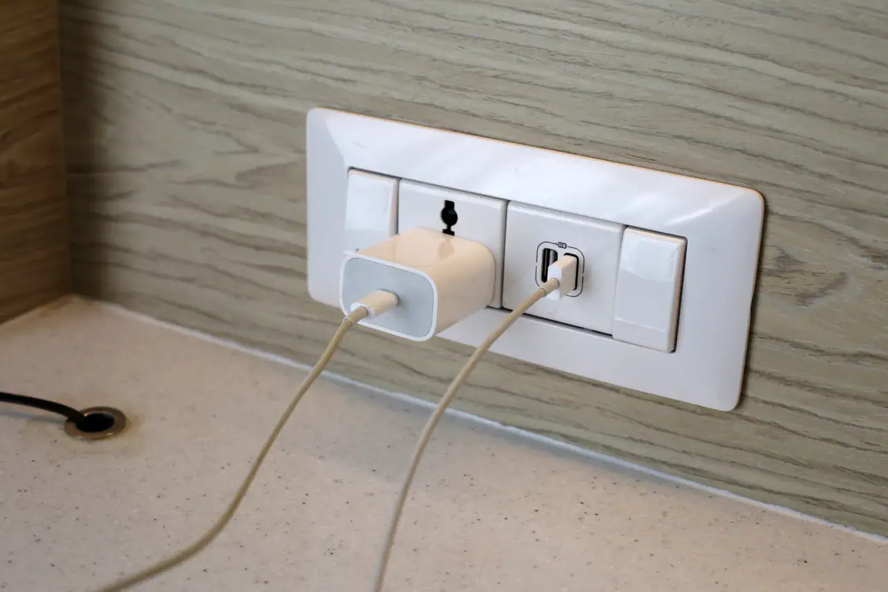 Phone charger and USB cable plugged into a new wall outlet with USB ports